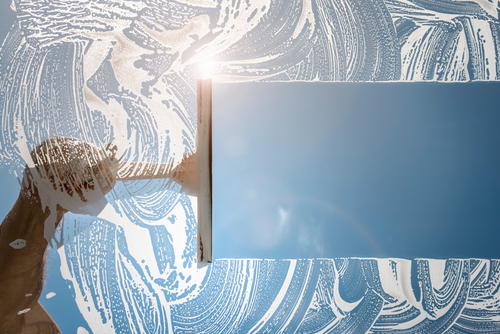 Window,Cleaner,Using,A,Squeegee,To,Wash,A,Window,With